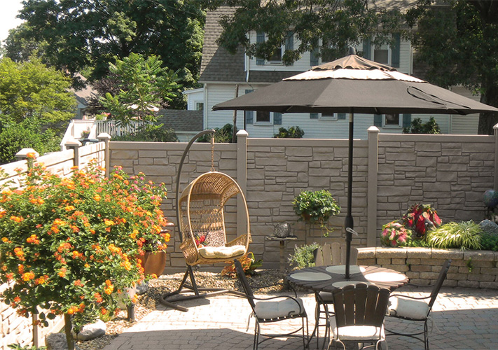 Tan stone Five Points simulated fencing surrounding a patio area.