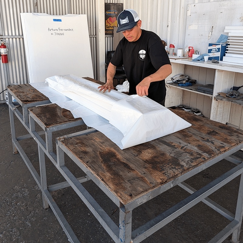 A Vinyl Craft employee wrapping up white fence posts after vinyl fabrication near Madera, California.